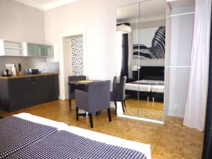 1 dormitorio con cama, mesa y cocina en 7 Rooms MTP, en Poznan