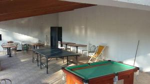 a pool table in a room with tables and chairs at Pousada Dedo de Deus in Paraisópolis