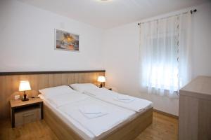 Posteľ alebo postele v izbe v ubytovaní Apartments Maslina II