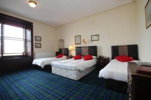 a hotel room with two beds with red pillows at The Anchorage Hotel in Troon