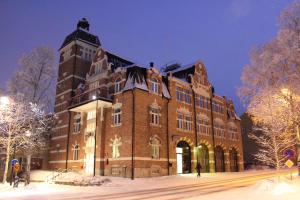 a large brick building in the snow at night at STF Östersund Ledkrysset in Östersund