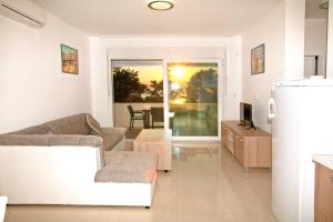 uma sala de estar com um sofá e uma mesa em Apartments Maslina II em Njivice