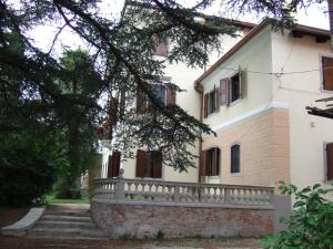 a white house with a stone fence and stairs at Antica Scuderia in Buttrio