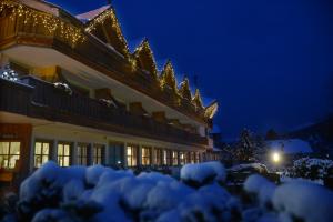 カヴァレーゼにあるPark Hotel Bellacostaの夜雪に覆われた建物