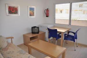 un soggiorno con tavolo, sedie e TV di Emejota a La Manga del Mar Menor