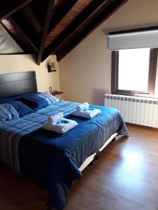 Un dormitorio con una cama azul con toallas. en Morena en El Chaltén
