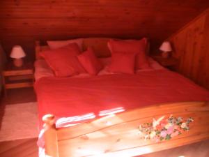 1 dormitorio con 1 cama con sábanas rojas y 2 lámparas en Gîte de la baerenbach, en Hazelbourg
