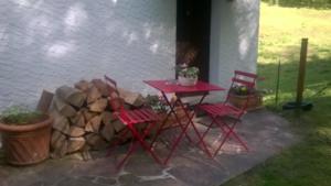 a red table and chairs on a patio at Gîte de la baerenbach in Hazelbourg +11 photos