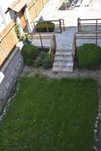 un patio trasero con escaleras, una valla de madera y césped en Terra Guest House, en Velingrad