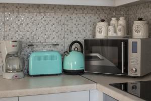 a kitchen counter with a microwave and a toaster at Gina's Cozy House in Kamilari