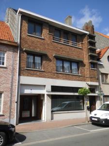 een bakstenen gebouw met een auto ervoor geparkeerd bij 't Eenvoud - Logies in Knokke-Heist