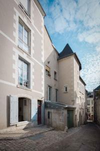 ein Gebäude mit einer roten Tür auf einer Straße in der Unterkunft Le Relais Du Petit Lion in Blois