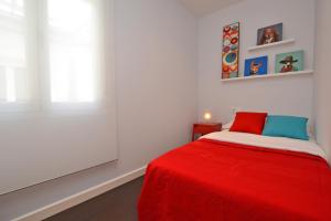 um quarto com uma cama vermelha e um cobertor vermelho em Ático con terraza en el centro de Alicante em Alicante