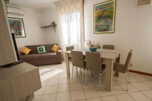 salon ze stołem, krzesłami i kanapą w obiekcie appartamento a cavallino w Cavallino-Treporti
