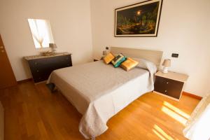 sypialnia z łóżkiem z 2 stolikami nocnymi i oknem w obiekcie appartamento a cavallino w Cavallino-Treporti
