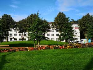 a white building with a bunch of flowers in a park at Dzintarjura in Ventspils