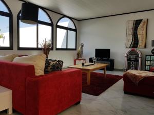 a living room with two red chairs and a table at Casa Los Islas in Playa del Ingles