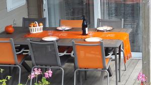 a table with orange table cloth and chairs on a patio at Le Chant Des Mûres in Plabennec