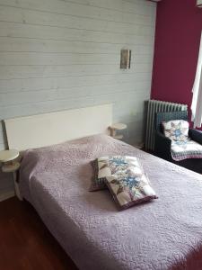 um quarto com uma cama com uma almofada em Hotel des Voyageurs em Mayenne