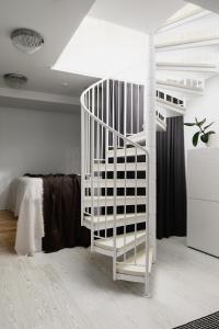 ヘルシンキにある2ndhomes Central two storey Apartment with saunaのベッド付きの客室内の白い螺旋階段