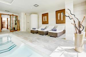 a living room with a tub and chairs at Grupotel Los Príncipes & Spa in Playa de Muro