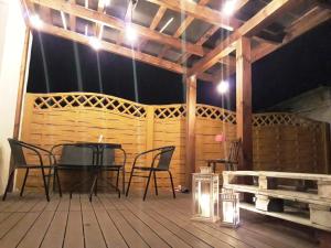 a wooden deck with a table and chairs and lights at Dom Adula in Janów Lubelski