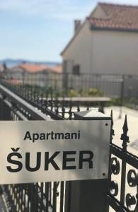 ein Schild auf einem Zaun mit dem aarantischen Vermessungszeichen darauf in der Unterkunft Apartments Šuker in Trogir
