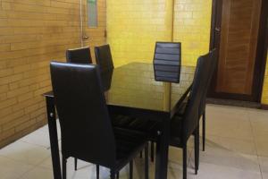 una mesa de comedor con sillas negras alrededor en The Park House, en Male