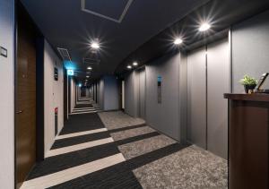 a corridor of a hallway with a row of walkways at Daiwa Roynet Hotel Nagoya Eki Mae in Nagoya