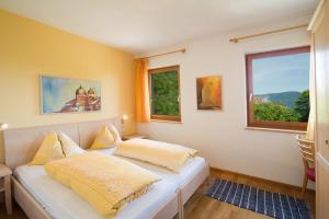 a bedroom with two beds and two windows at Schloss-Hof in Appiano sulla Strada del Vino
