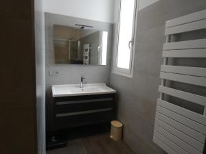 y baño con lavabo y espejo. en Maison Basque en Biarritz
