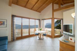 sala de estar con TV y mesa con sillas en Schloss-Hof, en Appiano sulla Strada del Vino