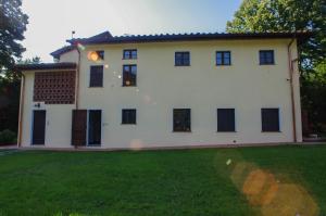 Casa blanca con ventanas negras y patio en CASALE LA FATA -tipico toscano immerso nelle colline tra Lucca e Versilia, 6 appartamenti indipendenti, en Camaiore