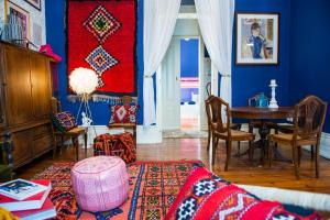 a living room with a table and a blue wall at La Palma Hostel Leiria in Leiria