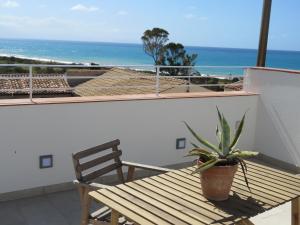 a wooden bench sitting on a balcony with a view of the ocean at casa verdemare in Cefalù
