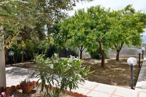 a garden with trees and plants and street lights at casa verdemare in Cefalù