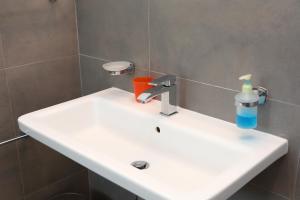 a bathroom sink with a toothbrush and a cup on it at casa verdemare in Cefalù