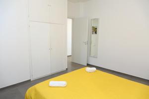 a bedroom with a yellow bed and white cabinets at casa verdemare in Cefalù