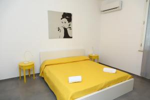 a bedroom with a yellow bed and two tables at casa verdemare in Cefalù