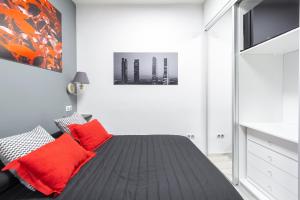 1 dormitorio con 1 cama con almohadas rojas en Argüelles Apartment en Madrid