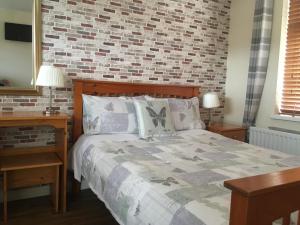 a bedroom with a bed with a brick wall at Amore Bed & Breakfast in Derry Londonderry