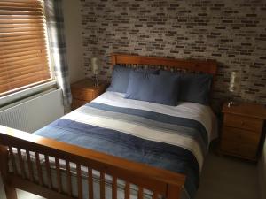 a bedroom with a wooden bed with blue pillows at Amore Bed & Breakfast in Derry Londonderry