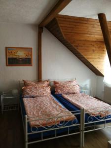 2 Betten in einem Schlafzimmer mit Holzdecke in der Unterkunft Pension Harmonie in Erfurt