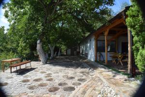 a patio with a bench next to a building at Guest House Mundzic- Sumski Mir in Irig