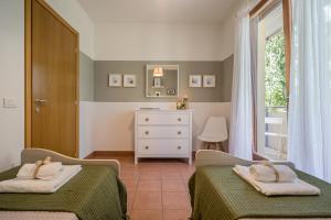 a bedroom with two beds and a dresser and a window at Callas Family Apartment in Sirmione +41 photos