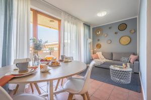 a living room with a table and chairs and a couch at Callas Family Apartment in Sirmione