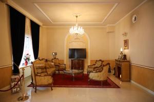sala de estar con sillas, TV y lámpara de araña en Hotel Ten Constanta en Constanza