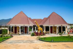 a giraffe statue in front of a house at Asmorein Hotel in Babati