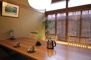 a wooden table with a tea kettle on top of it at Guest House Sawaragi in Kyoto