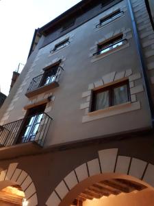 ein hohes weißes Gebäude mit Fenstern und einem Torbogen in der Unterkunft Allotjament turístic Cal Minguell in San Lorenzo de Morunys